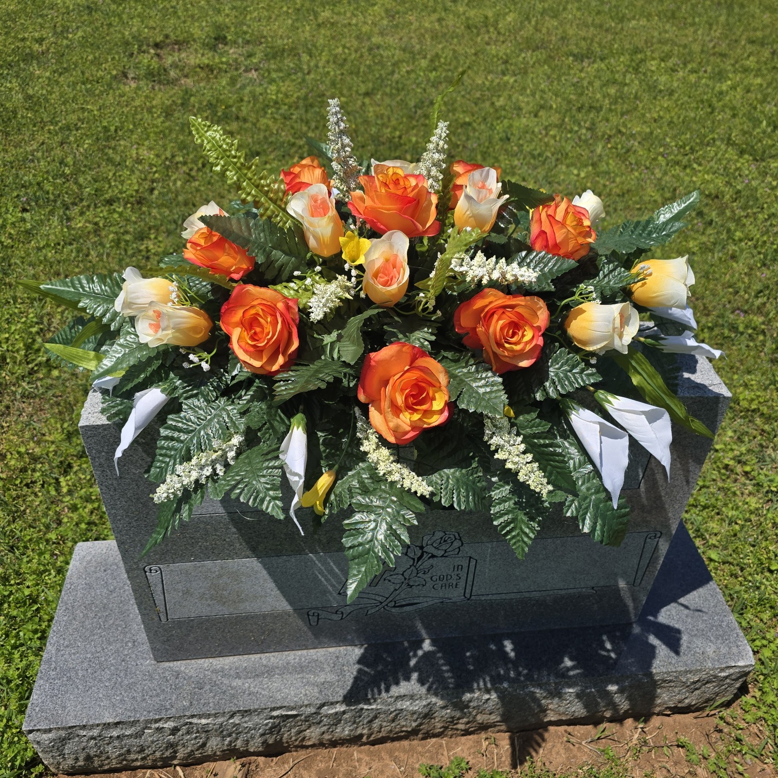 ORANGE AND WHITE HEADSTONE SADDLE WITH ORANGE ROSES & CALLA LILY’S FOR CEMETERY