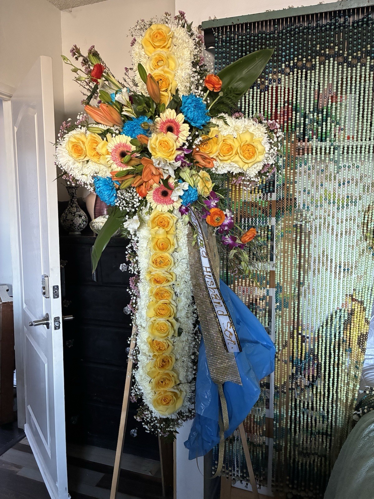 Cross-Shaped Floral Arrangement with Yellow, White, Blue, and Orange Flowers