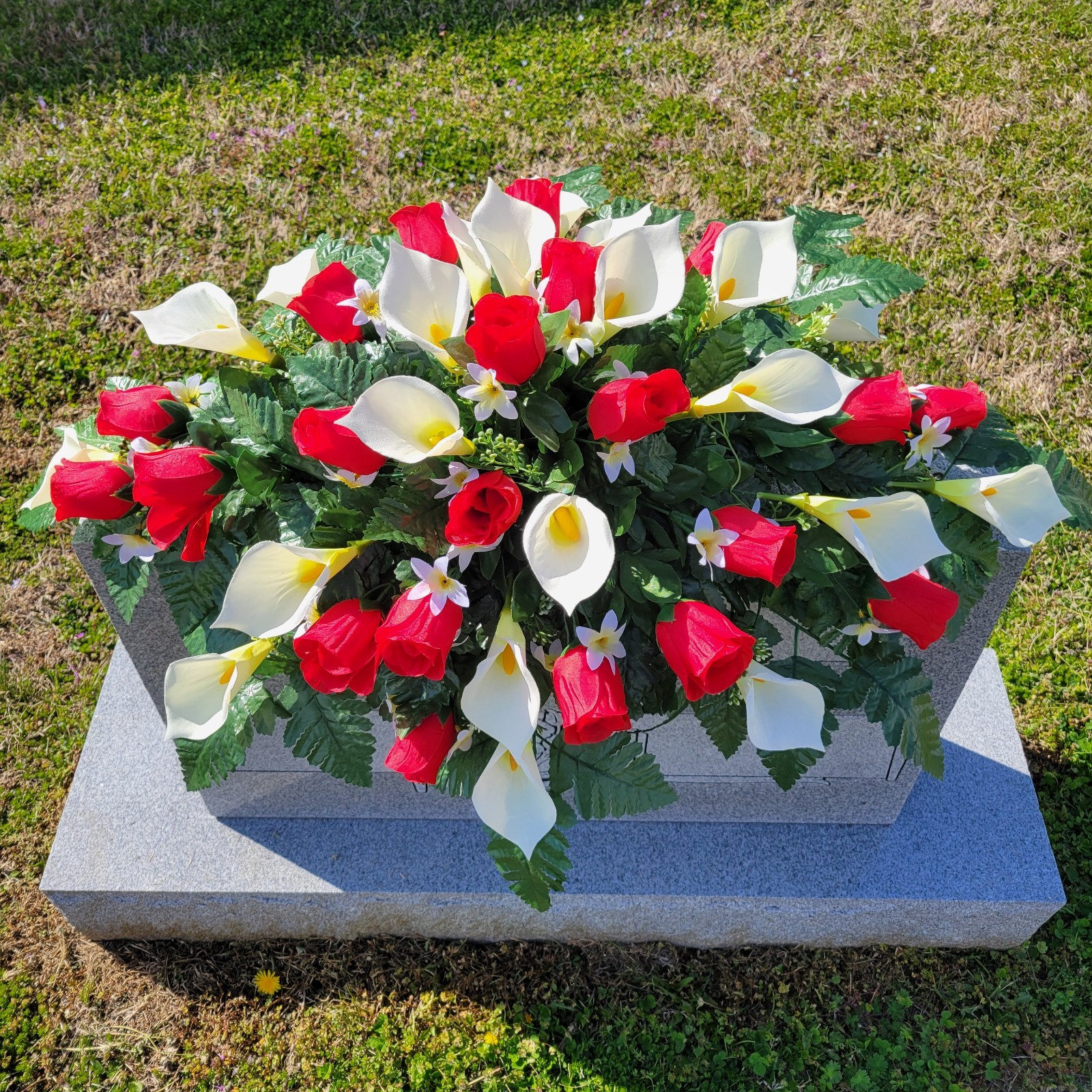 RED HEADSTONE SADDLE WITH ROSE BUDS & CALLA LILY’S FOR CEMETERY