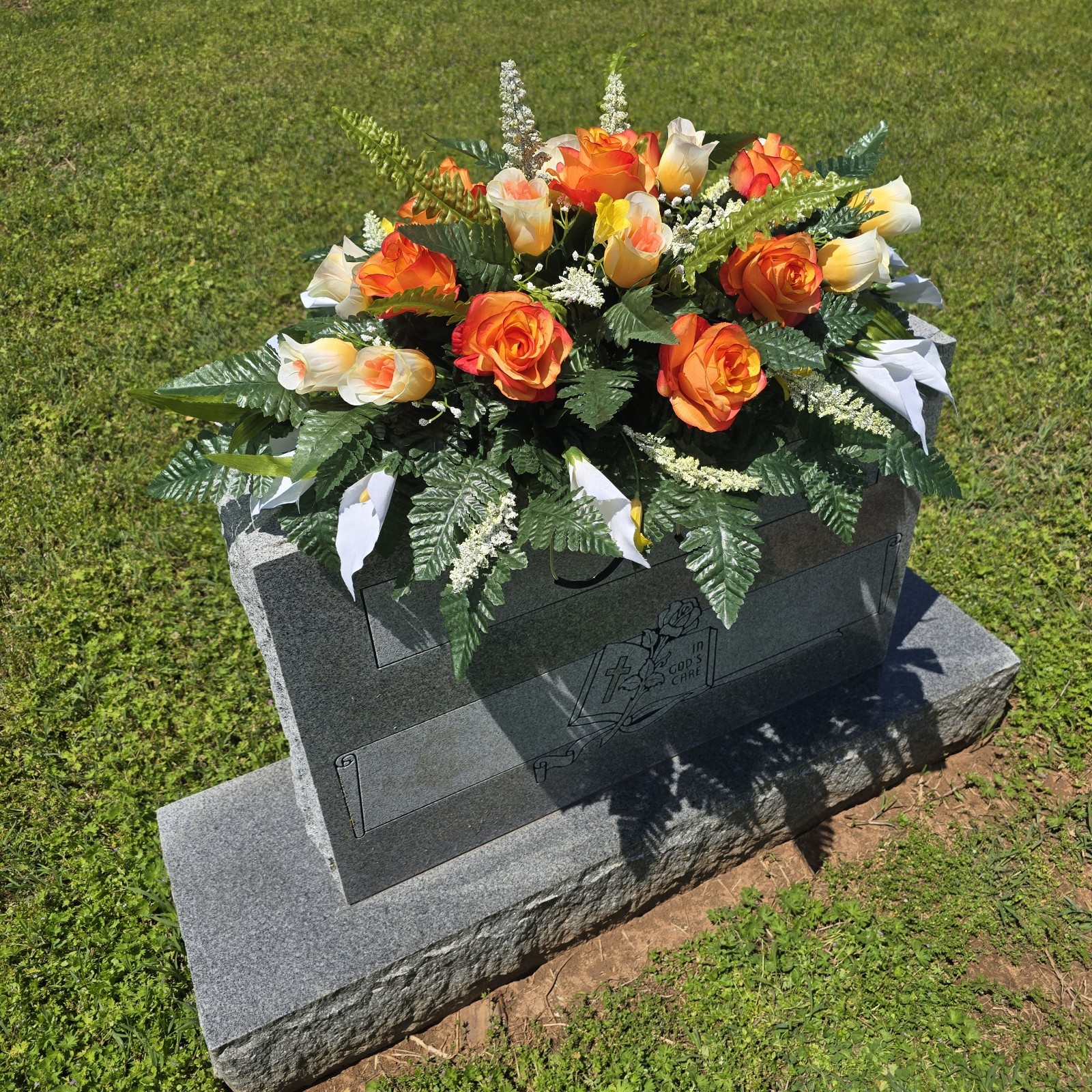 ORANGE AND WHITE HEADSTONE SADDLE WITH ORANGE ROSES & CALLA LILY’S FOR CEMETERY