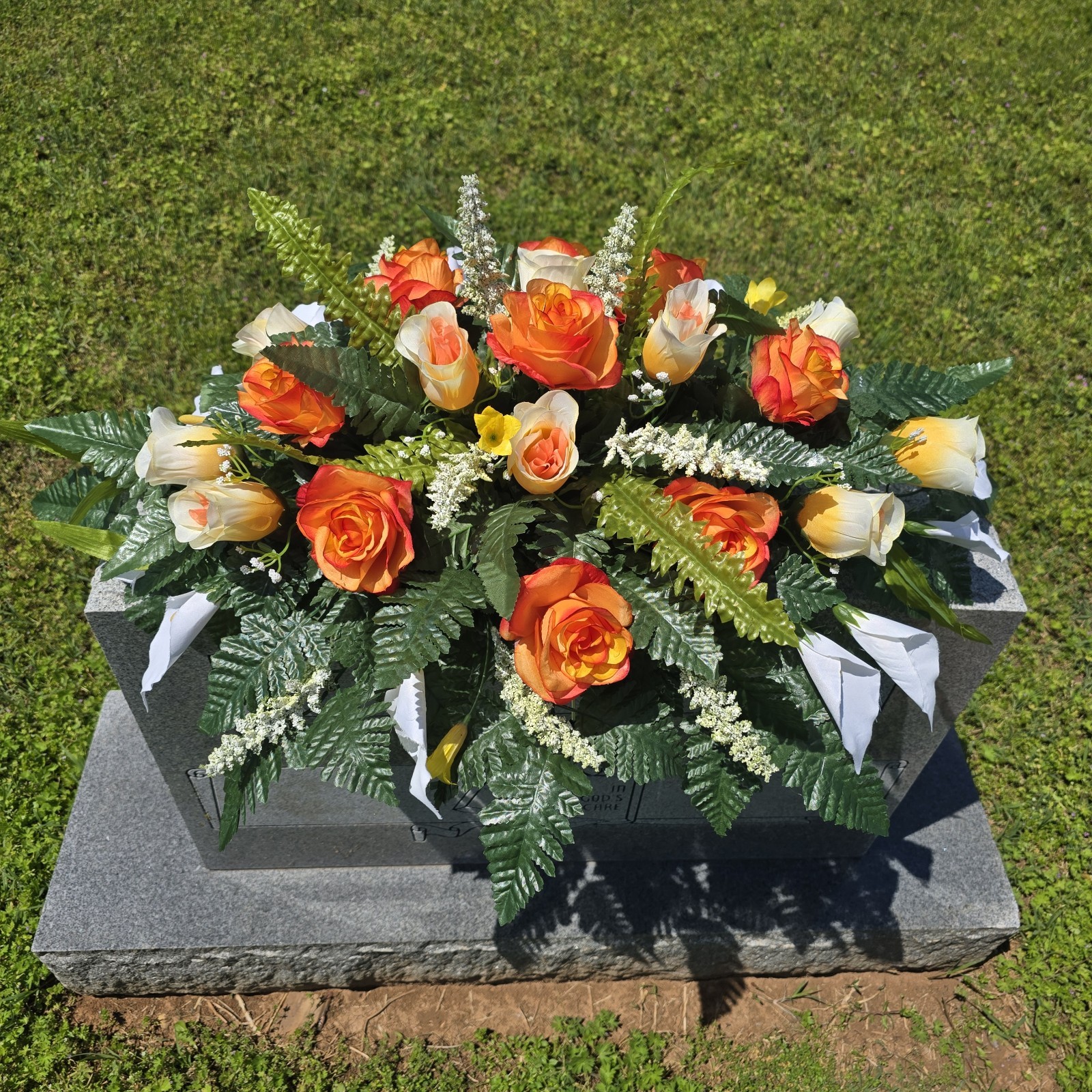 ORANGE AND WHITE HEADSTONE SADDLE WITH ORANGE ROSES & CALLA LILY’S FOR CEMETERY